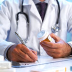 Doctor writing out RX prescription selective focus